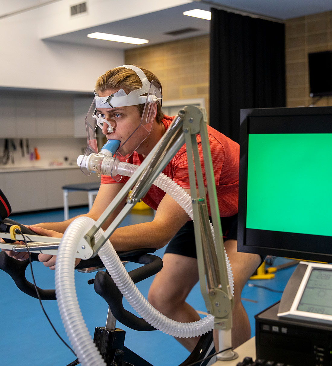athlete on respiratory monitors while peddling stationary bicycle