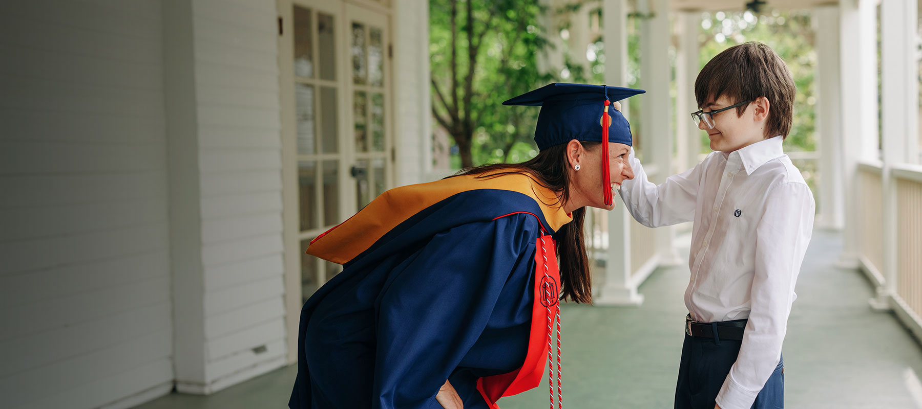 online graduate in regalia with her child