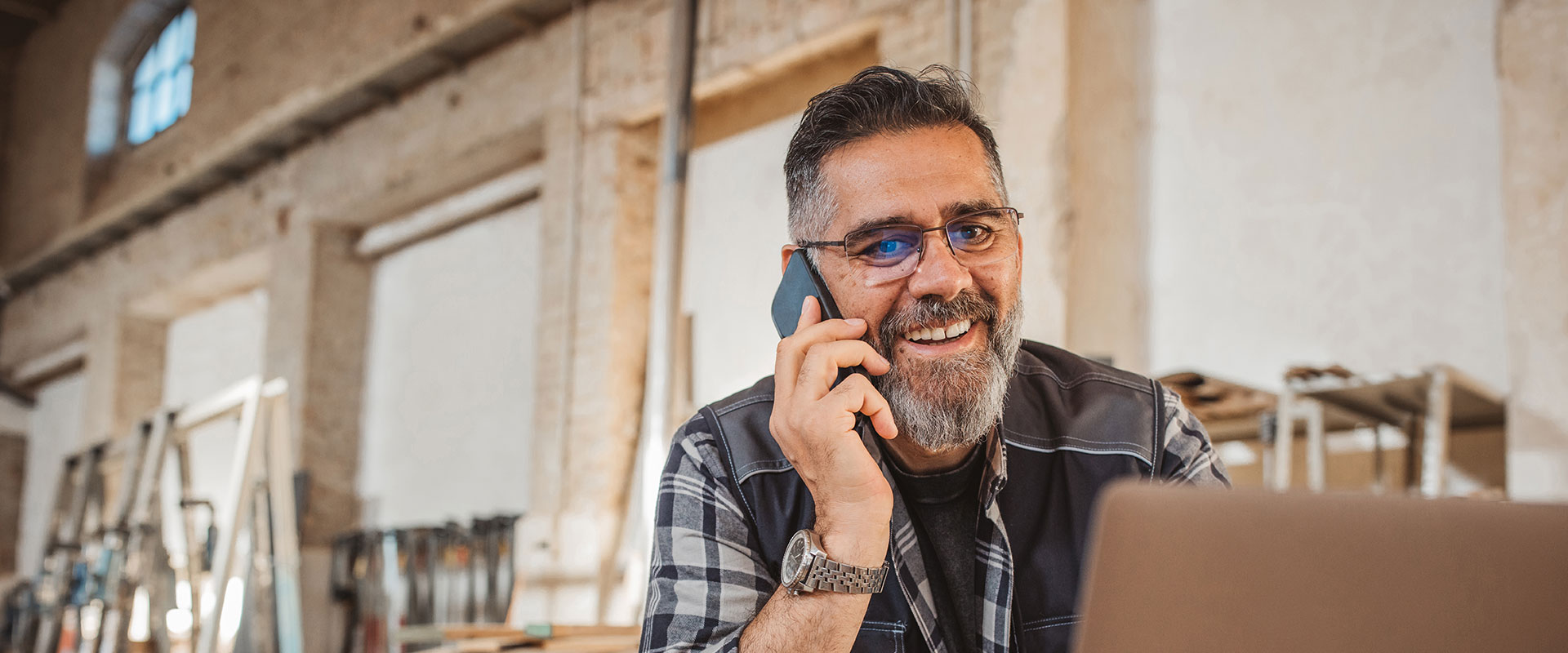 Entrepeneur on the phone at a desk in his place of business